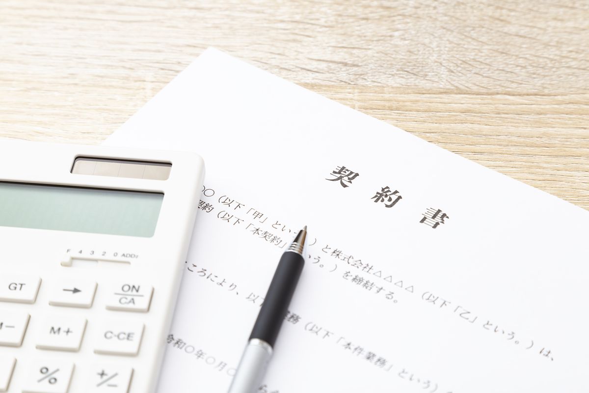自宅のデスクで契約書類を確認する手元