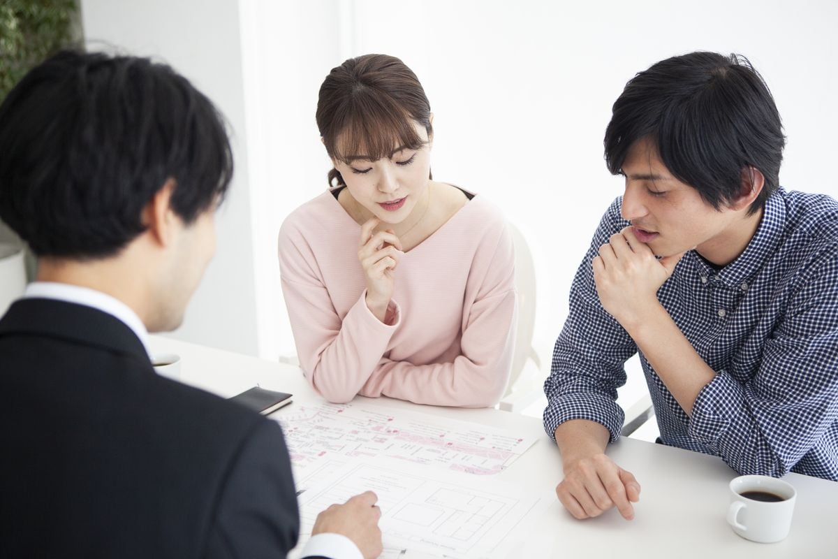 担当者と話しながら書類を確認する夫婦