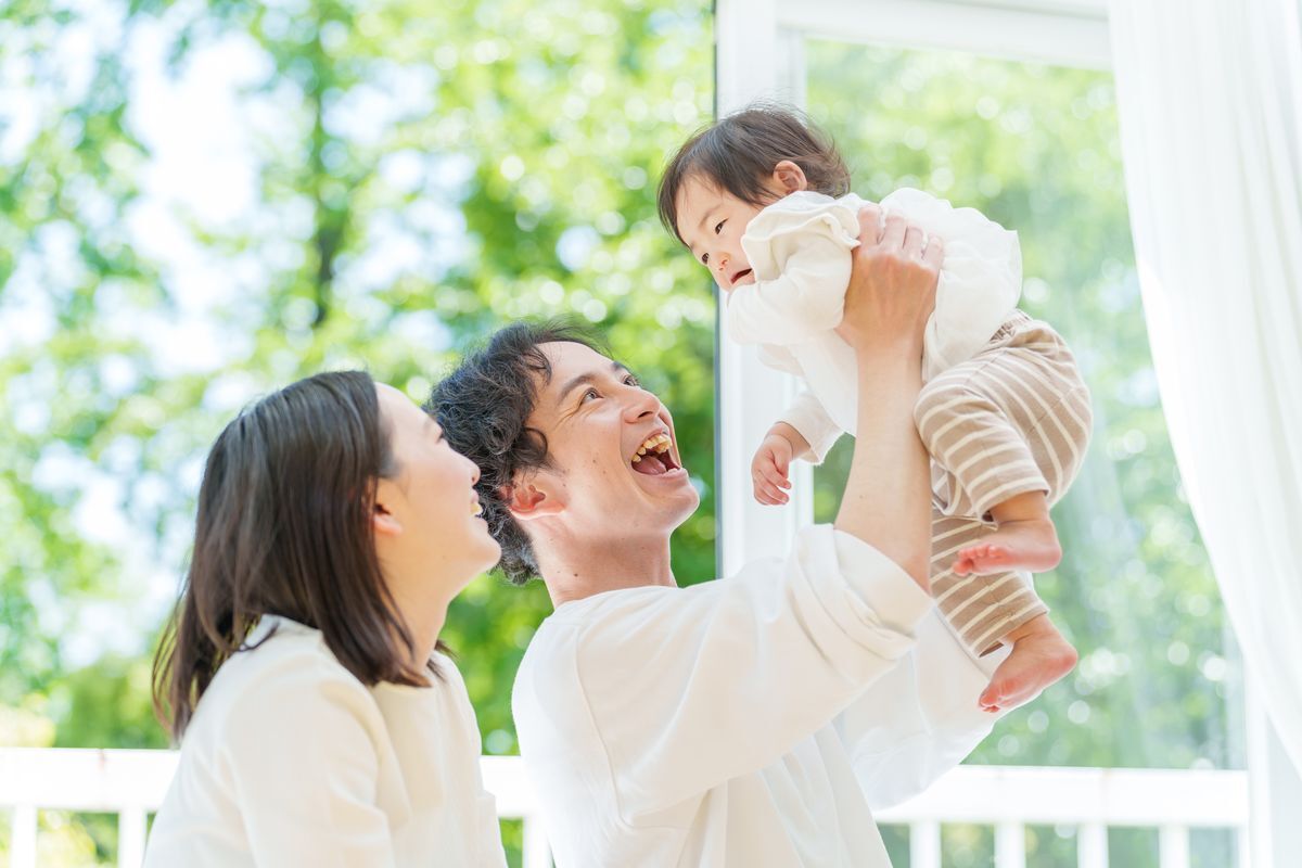 赤ちゃんを抱き上げる両親